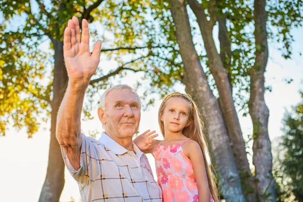 Дівчина з дідусем махає руками . — стокове фото