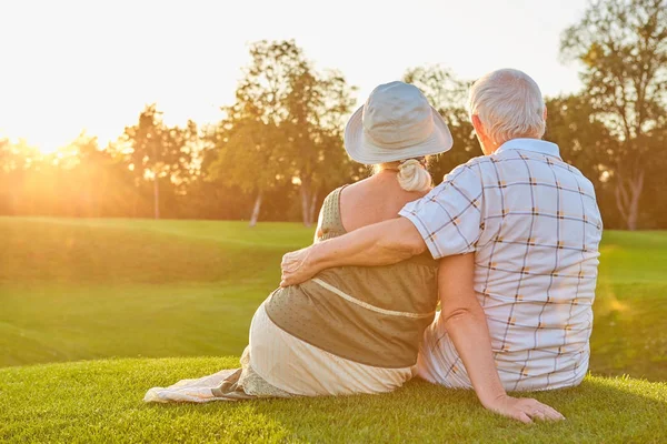 Casal senior sentado na grama. — Φωτογραφία Αρχείου