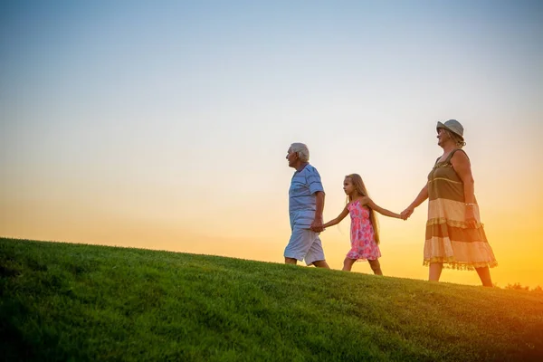 Chica con abuelos al atardecer . — Foto de Stock