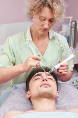 Makyajcısı microcurrent terapi cihazı ile.