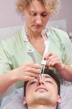 Microcurrent terapi cihazı kullanan kadın.