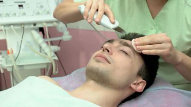 Ultrasonik yüz scrubber kullanarak eller.