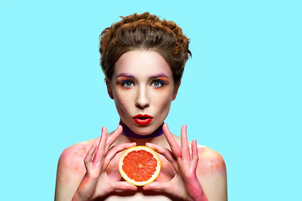 Surprised woman holding grapefruit slice. — Stock Photo, Image