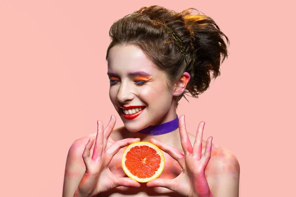 Smiling woman holding grapefruit slice. — Stock Photo, Image