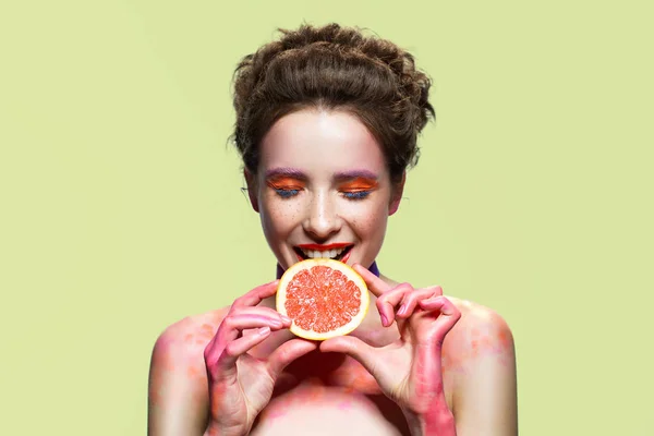 Pretty girl biting grapefruit slice. — Stock Photo, Image