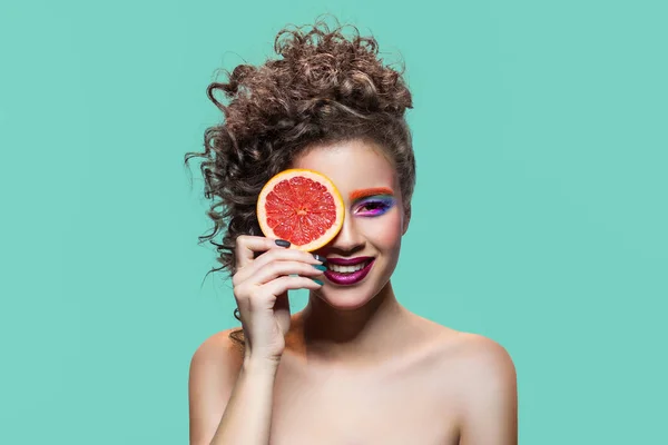 Happy girl holding grapefruit slice. — Stock Photo, Image