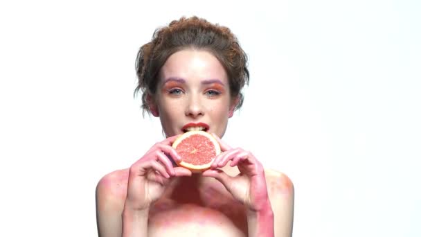 Mooi meisje bijten grapefruit segment. — Stockvideo