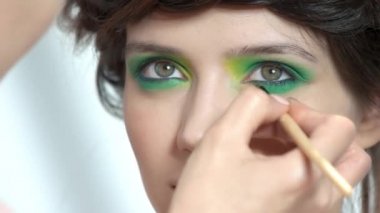 Yeşil göz farı olan kadın.