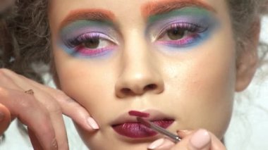 Visagist ruj fırçası kullanarak.