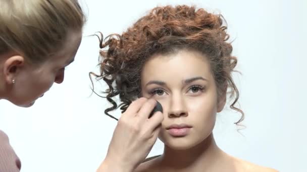 Visagist toepassing van make-up, jonge vrouw. — Stockvideo