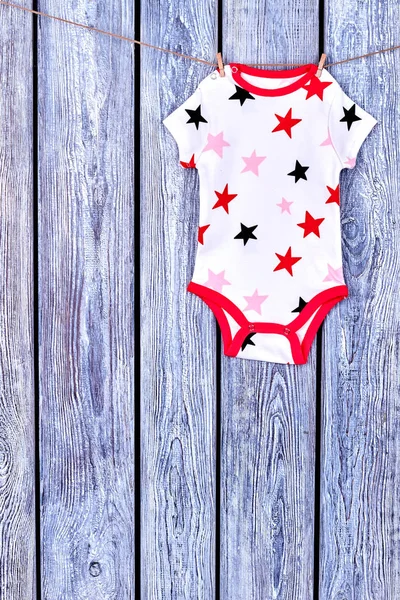 Infants cute bodysuit drying on rope. — Stock Photo, Image