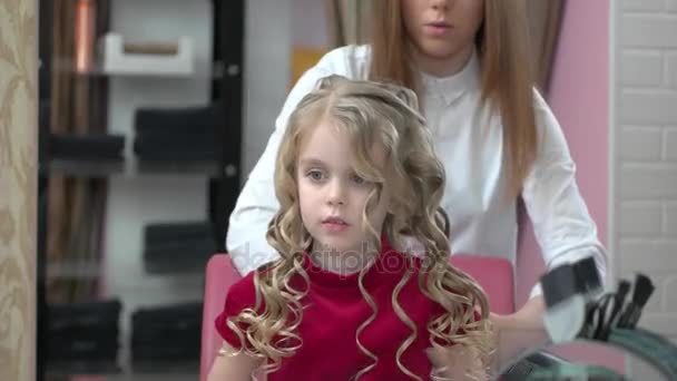 Стилист с помощью лака для волос, маленькая девочка . — стоковое видео