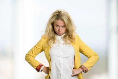 Kalça elleri ile genç sarışın ayakta.