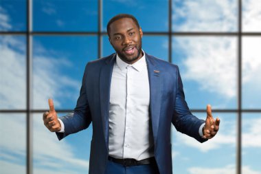 Mavi gökyüzü arka plan üzerinde koyu tenli işadamı.