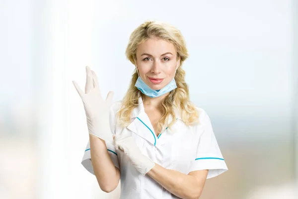 Enfermera joven poniéndose guantes . —  Fotos de Stock