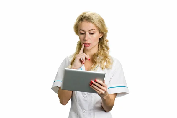 Nachdenkliche junge Krankenschwester mit PC-Tablet. — Stockfoto