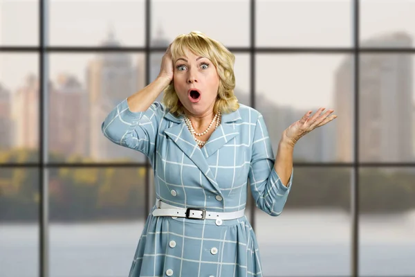 Señora de piel blanca sorprendida en el fondo de la ventana de la oficina . —  Fotos de Stock