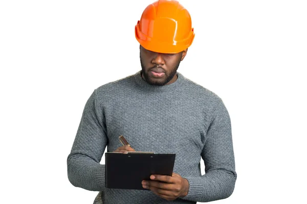 Serious engineer writing on clipboard. — Stock Photo, Image