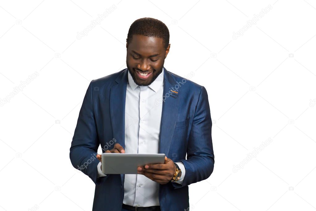 Smiling businessman working on computer tablet.