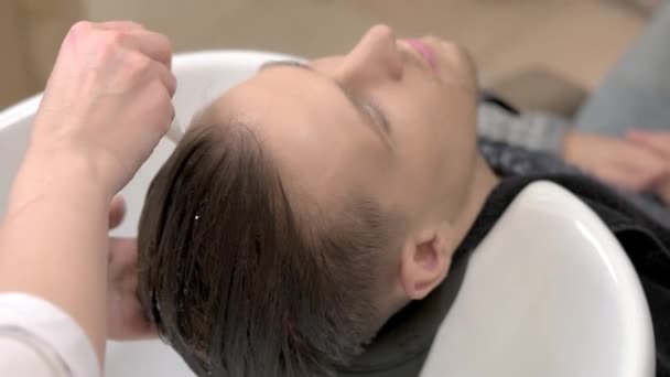 Руки перукаря нанесення шампуню . — стокове відео