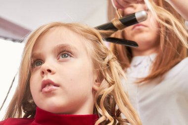 Çocuk saçlarını oluyor.