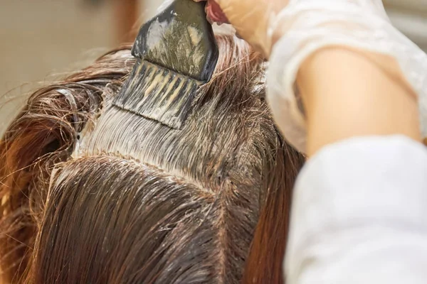 Brush applying dye on hair.