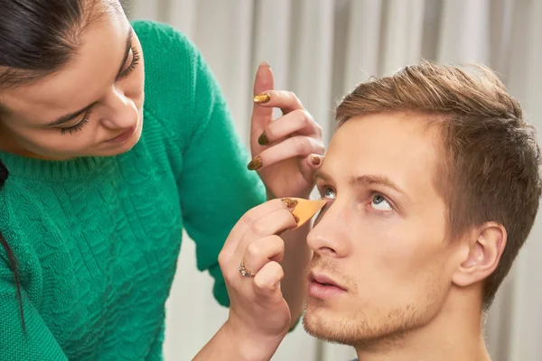 Visagista aplicando fundação, modelo masculino . — Fotografia de Stock