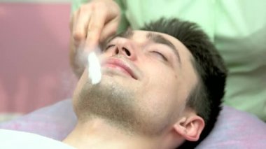 Genç adamın, cryomassage yüzünü.