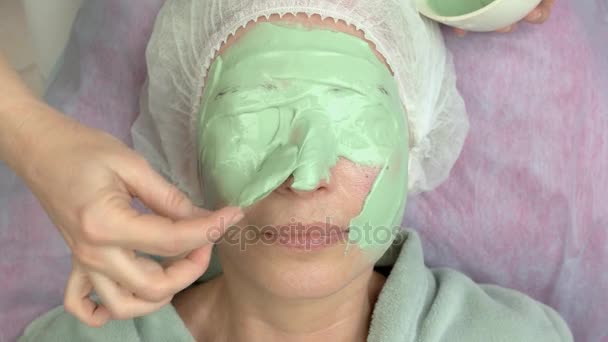 Косметик наносит альгинатную маску для лица . — стоковое видео