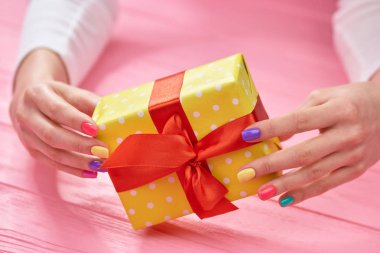 Hediyelik kutu manikürlü eller içinde.