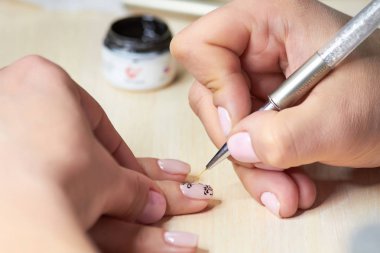 The drawing process on female nails. clipart