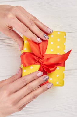 Erkek manikürlü eller ve hediye kutusu.