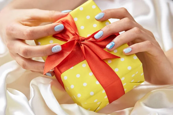 Hediyelik kutu manikürlü eller içinde.