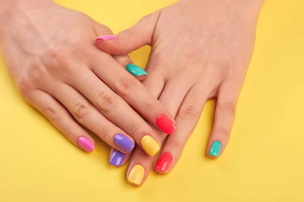 Mujer uñas pintadas en diferentes colores . — Foto de Stock