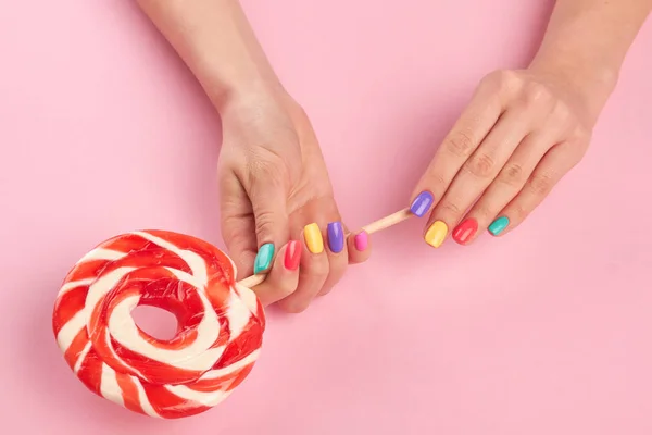 Bright lollipop in female hands. — Stock Photo, Image