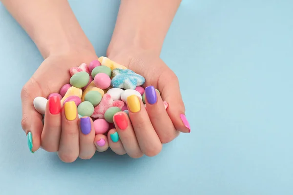 Frauenhände mit bunten Bonbons. — Stockfoto