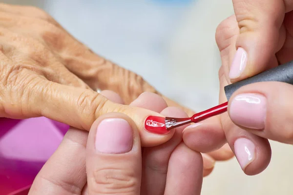 Esteticista aplicando verniz vermelho para unhas de mulher . fotos, imagens  de © Denisfilm #200364000