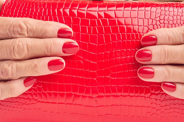 Bolso de cuero rojo de cerca en manos femeninas . — Foto de Stock