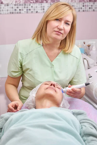 Mature woman, hand of cosmetologist. — Stock Photo, Image