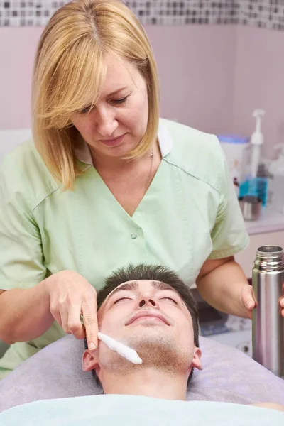 Yüz cryomassage, genç adam.