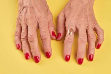 Kırmızı manikür ile yaşlı kadın el.