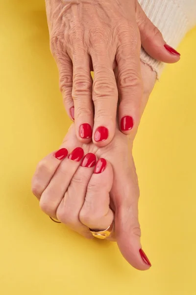 Las manos ancianas con manicura roja . —  Fotos de Stock