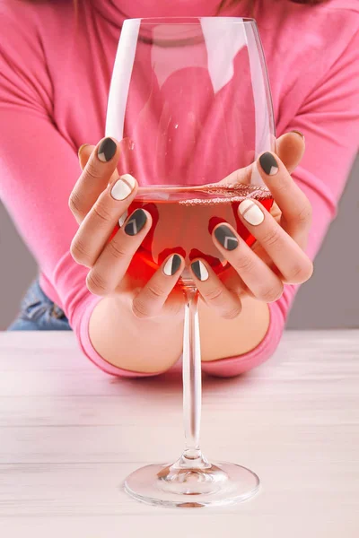 Glass of wine in manicured female hands. — Stock Photo, Image