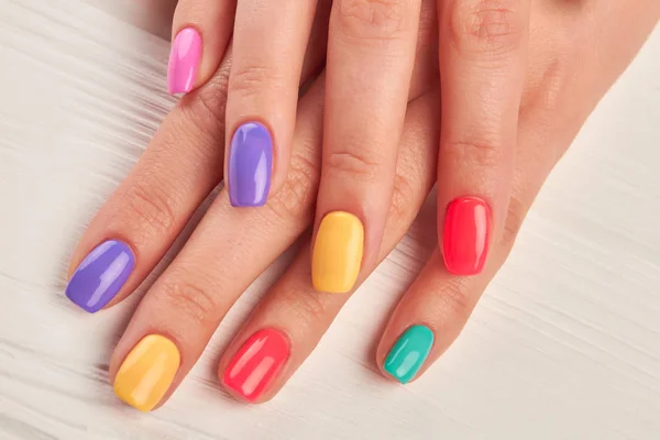 Vrouwelijke vingers met kleurrijke nagels. — Stockfoto