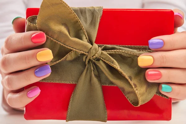 Hediye kutusunda manikürlü eller.