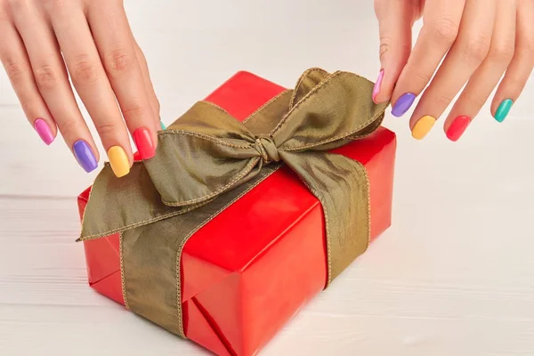 Erkek manikürlü eller ve hediye kutusu.