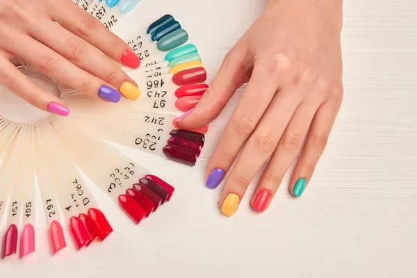 Well-groomed hands and nail color samples.