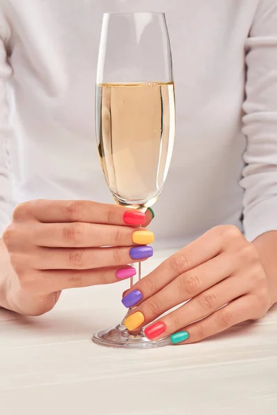 Glass of champagne in manicured hands. — Stock Photo, Image