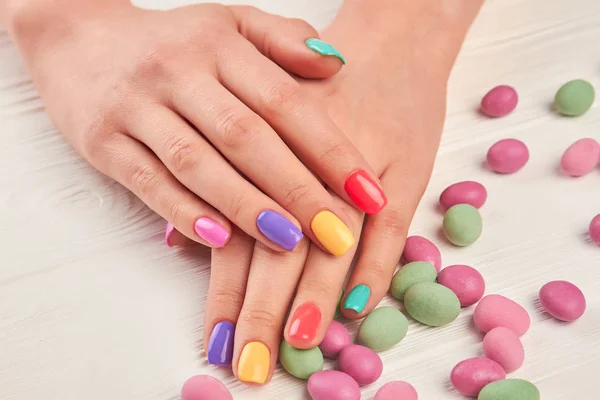 Multicolored manicure and candies close up. — Stock Photo, Image