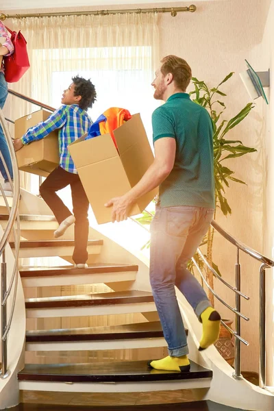 People with boxes walking upstairs.